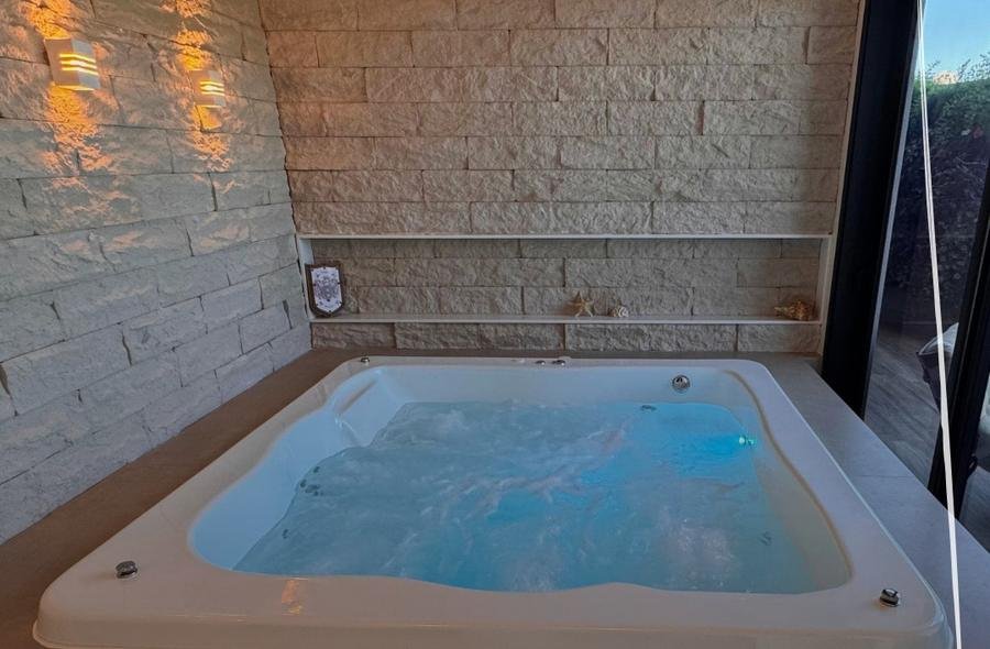 Spa de hidromassagem para cinco pessoas embutido em alvenaria com iluminação azul